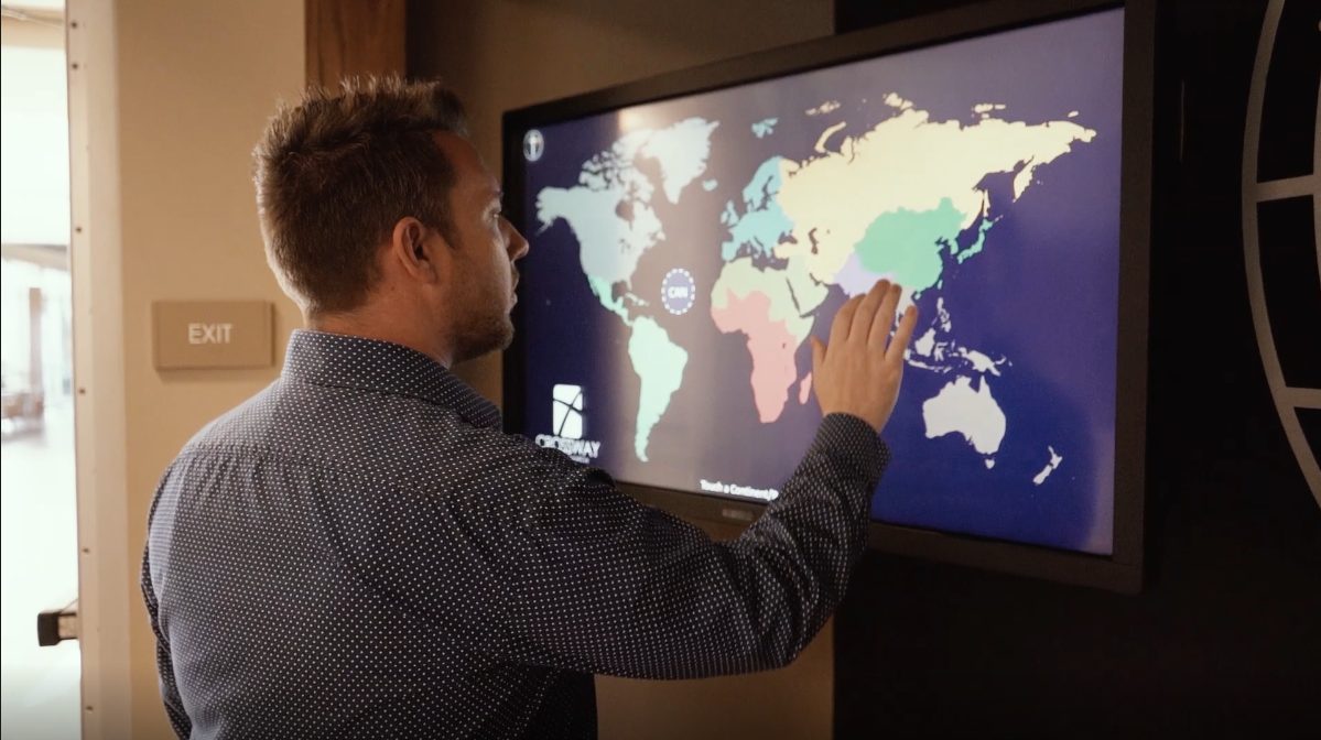 man using digital missions display touching screen to navigate